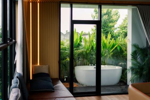 a bath tub in a room with a window at Family Room by 233Poshtel in Lampang