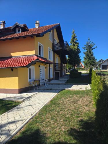 a yellow house with a red roof at Vila Kostic in Zlatibor