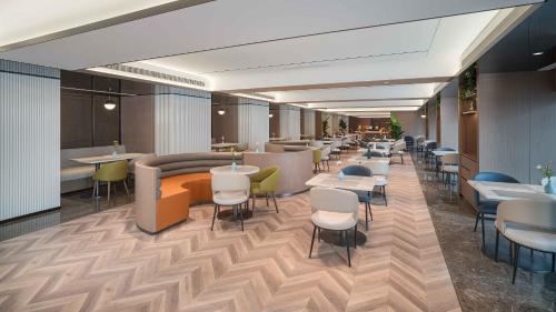 Un restaurante con mesas y sillas en una habitación. en Holiday Inn Express Xi'an Fengdong by IHG, en Xianyang