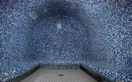 a room with a couch in a wall of mosaic tiles at Casablanca Apart Hotel in Bishkek