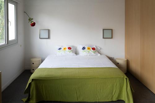a bedroom with a large bed with a green blanket at ResArt Traditional House in Nicosia