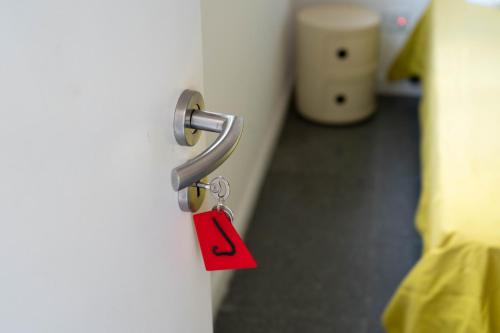 a red tag hanging from a door knob at ResArt Traditional House in Nicosia