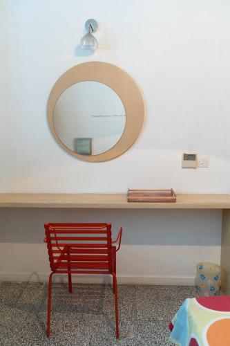 a red chair sitting under a table with a mirror at ResArt Traditional House in Nicosia