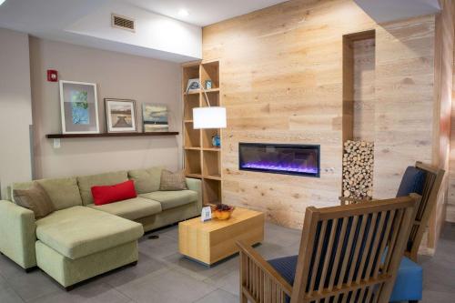 a living room with a couch and a fireplace at Country Inn & Suites by Radisson, Wilmington, NC in Wilmington