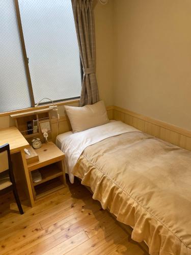 a bedroom with a bed and a desk and a window at Business Hotel Crescent - Vacation STAY 49950v in Tokyo
