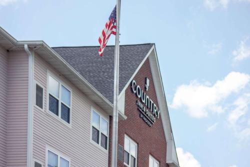 a building with an american flag on top of it at Country Inn & Suites by Radisson, Wilmington, NC in Wilmington