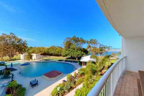 a balcony view of a swimming pool and the ocean at Gemini Resort, 2bedroom Unit19 and carpark Golden Beach, Caloundra in Golden Beach