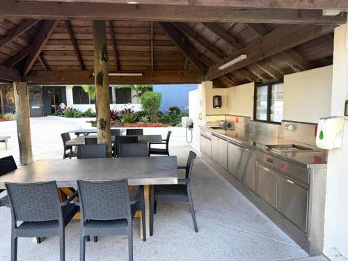 a patio with a table and chairs and a kitchen at Gemini Resort, 2bedroom Unit19 and carpark Golden Beach, Caloundra in Golden Beach