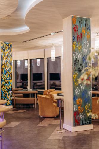 a lobby with chairs and paintings on the walls at Qafqaz Sahil Hotel Baku in Baku