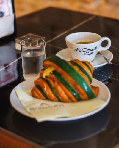 a plate of food and a cup of coffee on a table at Anna Teresa Luxury in Pisa