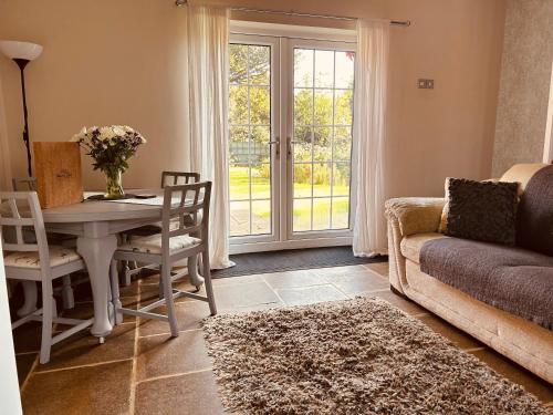 a living room with a table and a couch at The Old Coach House at Stewton in Louth