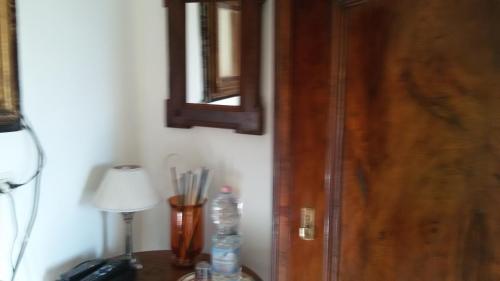 a room with a wooden door and a table with a lamp at Villa Fiorita in Monfalcone
