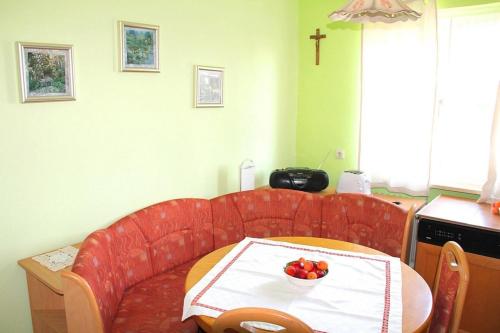 a kitchen with a table with a bowl of fruit on it at Ferienwohnung Nr 2, neben einem Bauernhof, Roßhaupten, Allgäu in Roßhaupten