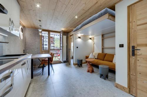 une cuisine et un salon avec un canapé et une table dans l'établissement Appartement Ski aux Pieds 2100m - Le Nid Tignes Val Claret, à Tignes