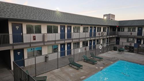 an apartment building with a swimming pool and chairs at Motel 6-Blythe, CA in Blythe