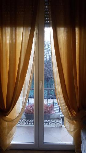 a window with curtains in front of a door at Villa Fiorita in Monfalcone