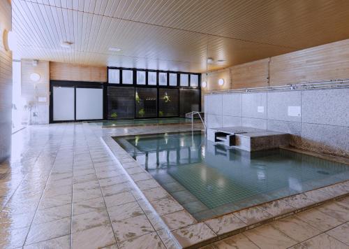 an indoor pool in a building with a swimming pool at Higashikawa Asahidake Onsen Hotel Bear Monte in Higashikawa