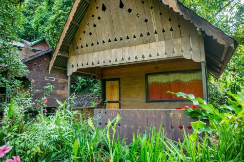 a small house in the middle of a garden at Pak Mus Guest House Ketambe - 0813-7072-1793 in Kutacane