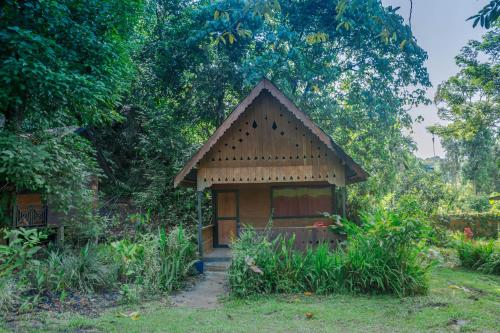 a small house in the middle of a garden at Pak Mus Guest House Ketambe - 0813-7072-1793 in Kutacane