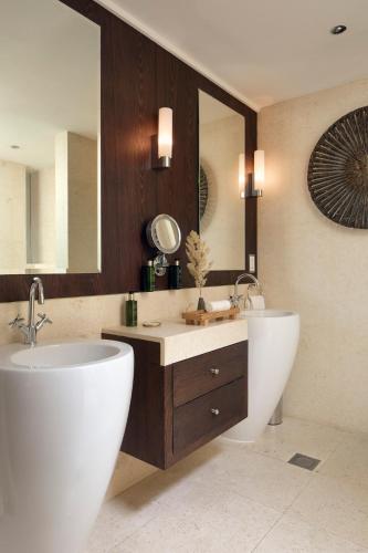 a bathroom with two sinks and a large mirror at Meliá Desert Palm Member of Meliá Collection in Dubai