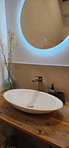 a bathroom with a white sink and a mirror at Chambre d'hôte de charme L'Escapada Les Échappées Belles in Antignac