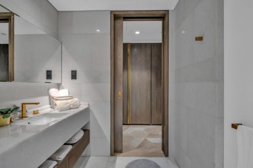 迪拜Palm Haven Luxe 3 Bed Townhouse with Private Pool的一间带水槽和木门的浴室