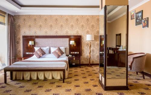 キガリにあるLemigo Hotelのベッドと鏡のあるホテルの部屋
