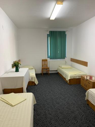 a room with three beds and a green curtain at Centrul Gaudeamus in Sighişoara