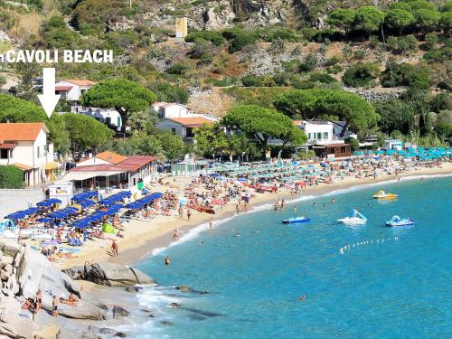 a beach with a lot of people in the water at Cavoli Beach - ArgonautiVacanze in Marina di Campo