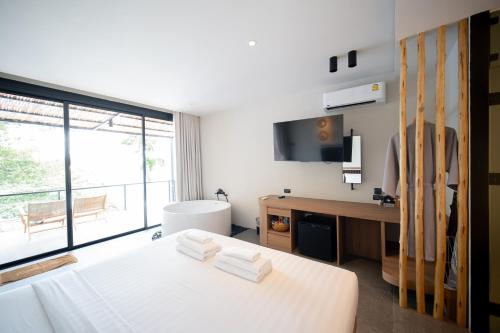 a bedroom with a bed and a desk and a window at Sangthian Beach Resort in Ko Samed
