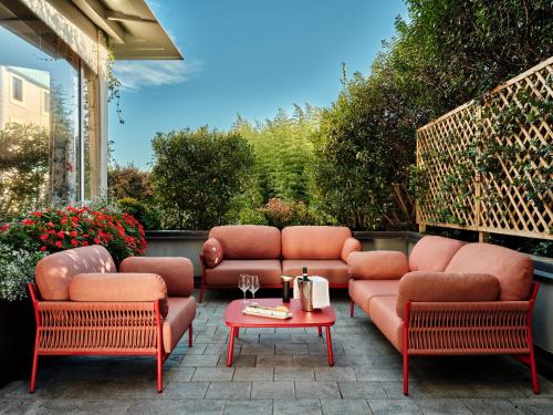 a patio with a couch and chairs and a table at Crowne Plaza Milan - Malpensa Airport by IHG in Case Nuove