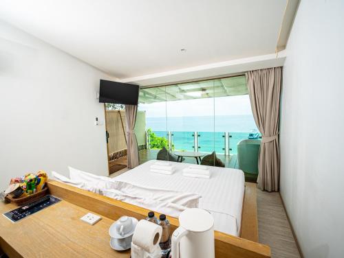 a bedroom with a bed and a view of the ocean at Sangthian Beach Resort in Ko Samed