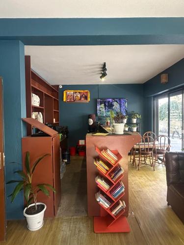 salon z niebieskimi ścianami i stołem z książkami w obiekcie Norbu Hotel w Katmandu