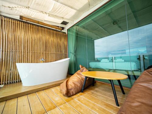 a bathroom with a tub and a table and a bath tub at Sangthian Beach Resort in Ko Samed