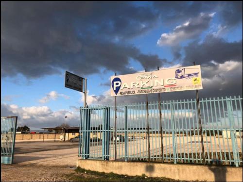 un cartello di parcheggio su una recinzione accanto a un parcheggio di La casa di Mimmo a Foggia