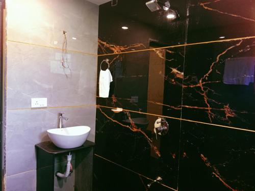 a bathroom with a sink and a mirror at Dattatray Hollydays 3bhk with balcony isolated in Mahabaleshwar