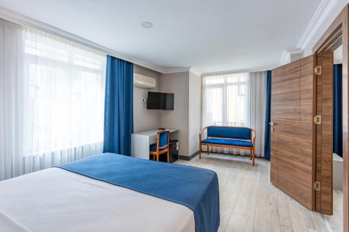 a bedroom with a bed and a desk and a chair at Safari Otel in Antalya
