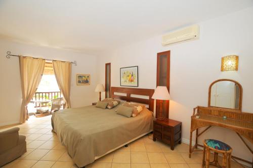 a bedroom with a bed and a piano at Ernestville 2 beachfront Villa Pointe aux Canonniers in Pointe aux Cannoniers