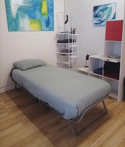 Ce lit se trouve dans un dortoir doté d'un mur blanc. dans l'établissement Relais Art Bien-Etre Lumineux Doué en Anjou, à Doué-la-Fontaine