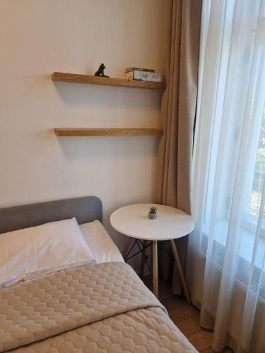 a bedroom with a bed and a table and a window at Cozy Studio Apartments 47 in Tallinn