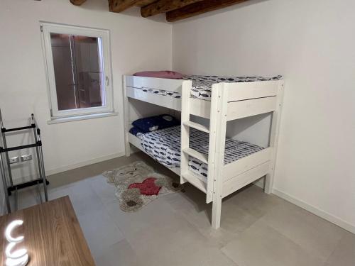 a white bunk bed in a room with a window at B&B da Mimì in San Vito al Tagliamento