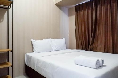 a bedroom with a bed with two towels on it at Comfy and Exclusive 2BR Apartment at Tanglin Supermall Mansion By Travelio in Surabaya
