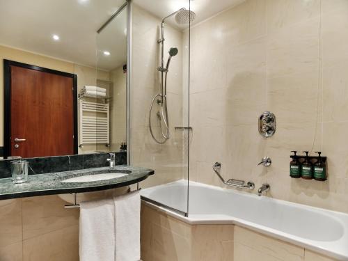 a bathroom with a tub and a sink and a shower at Crowne Plaza Milan - Malpensa Airport by IHG in Case Nuove