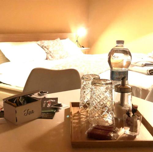 a bottle and glasses on a table in a bedroom at Mini Alloggi Il Vigneto del Borgo in Due Carrare