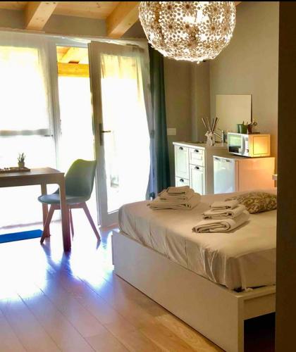 a bedroom with a bed and a desk and a chandelier at Mini Alloggi Il Vigneto del Borgo in Due Carrare
