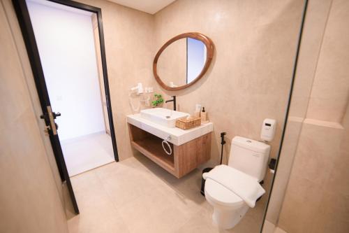 a bathroom with a toilet and a sink and a mirror at Ubu Villa Amarta in Yogyakarta in Ngaglik