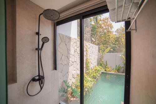 a shower in a bathroom next to a swimming pool at Ubu Villa Amarta in Yogyakarta in Ngaglik