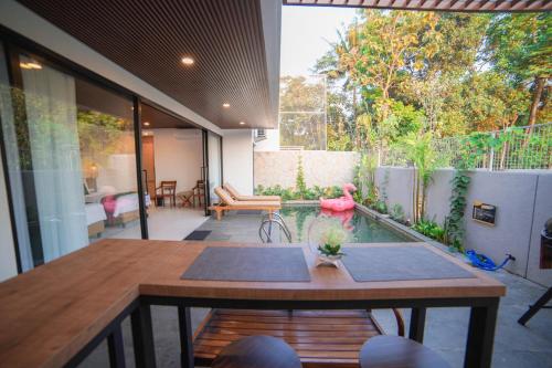 a patio with a table and a pool in a house at Ubu Villa Amarta in Yogyakarta in Ngaglik