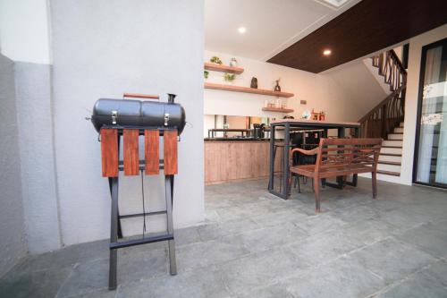 a room with a table and a stool with a suitcase at Ubu Villa Amarta in Yogyakarta in Ngaglik