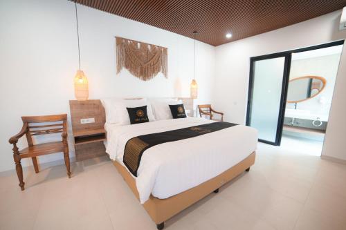 a bedroom with a large bed and a chair at Ubu Villa Amarta in Yogyakarta in Ngaglik